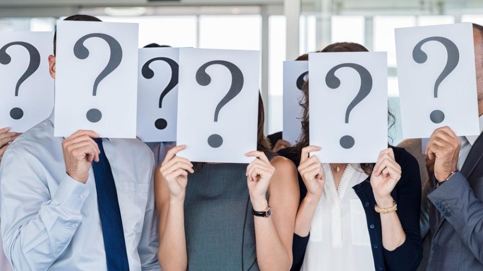 kantoormedewerkers met vraagtekenborden voor hun hoofden