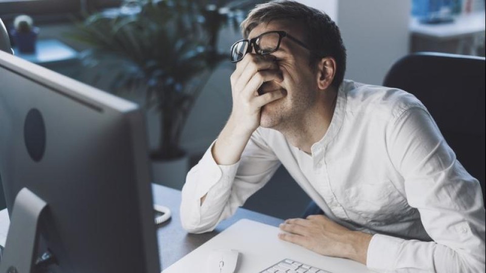 Main achter monitor wrijft ver,oeid in zijn ogen