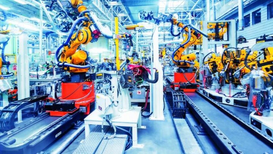 Een lopende band met robots, in een fabriek.