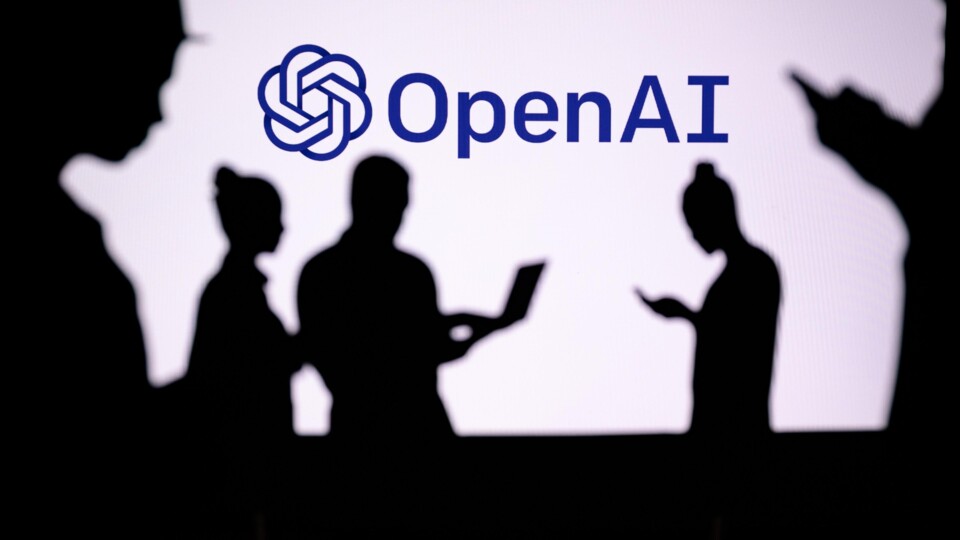 Schaduwen van vijf mensen voor een wit scherm met het blauwe OpenAI-logo en tekst.
