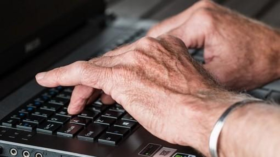 Oudere handen op laptop