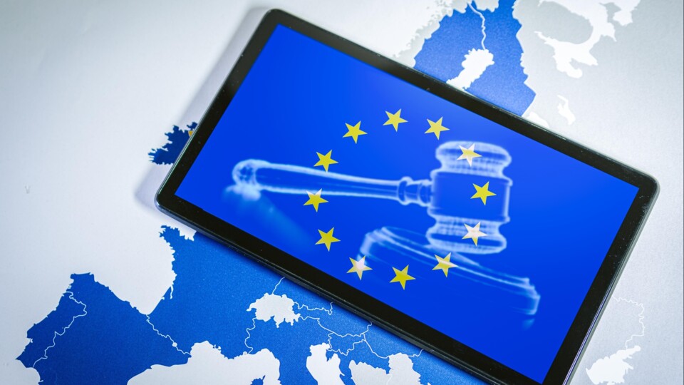 De Europese sterren op een beeldscherm, op de achtergrond een hamer van een rechter, en de kaart van Europa.