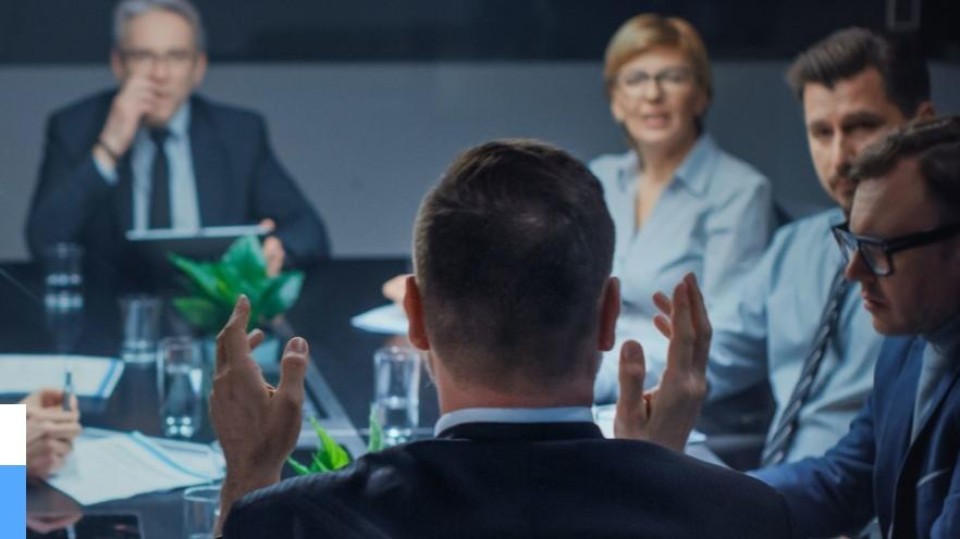 Man gezien op de rug spreekt bestuursvergadering toe