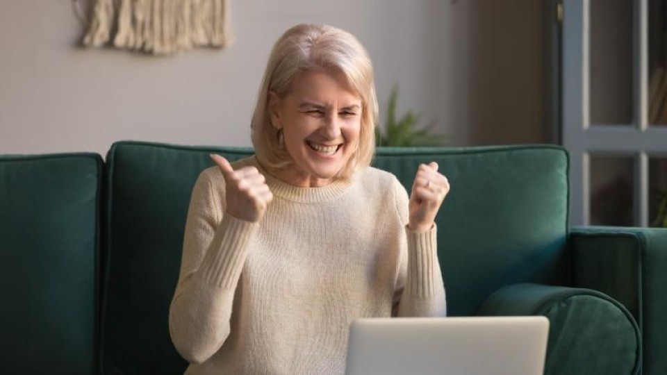 Oudere vrouw laptop blij