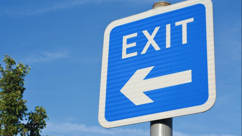 Bord met Exit en een pijl met op de achtergrond wolkjes