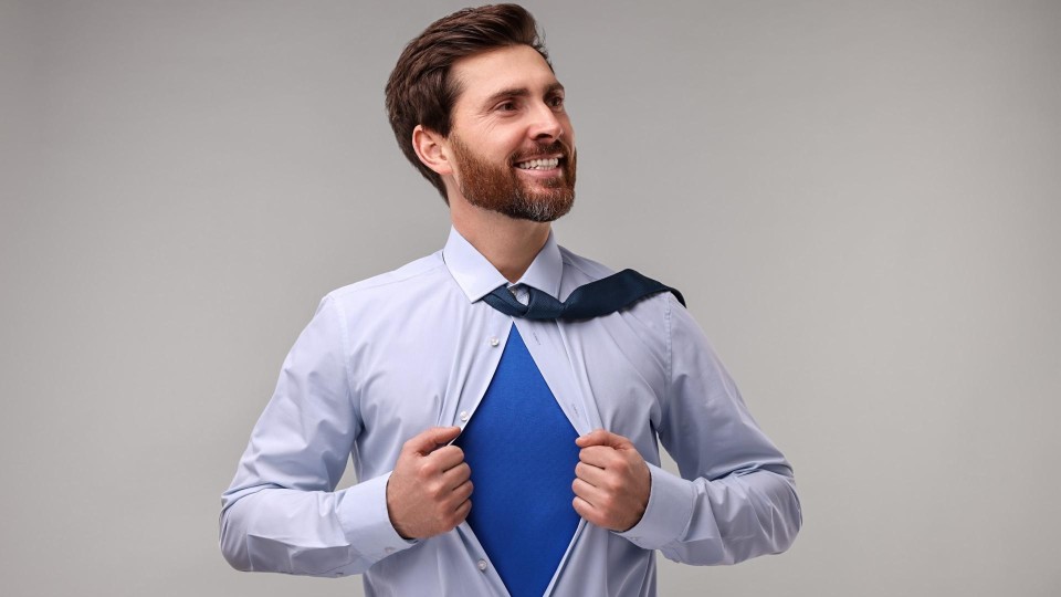 Zakenman trekt shirt open met daaronder een superman-shirt