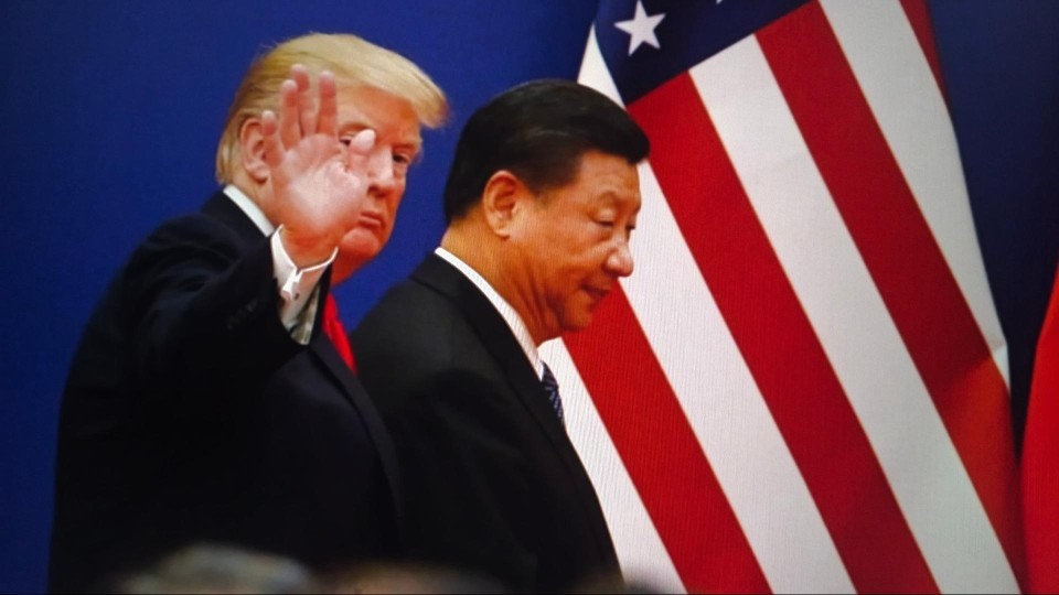 Trump met afwerend gebaar naar camera naast Xi en de Amerikanse vlag 