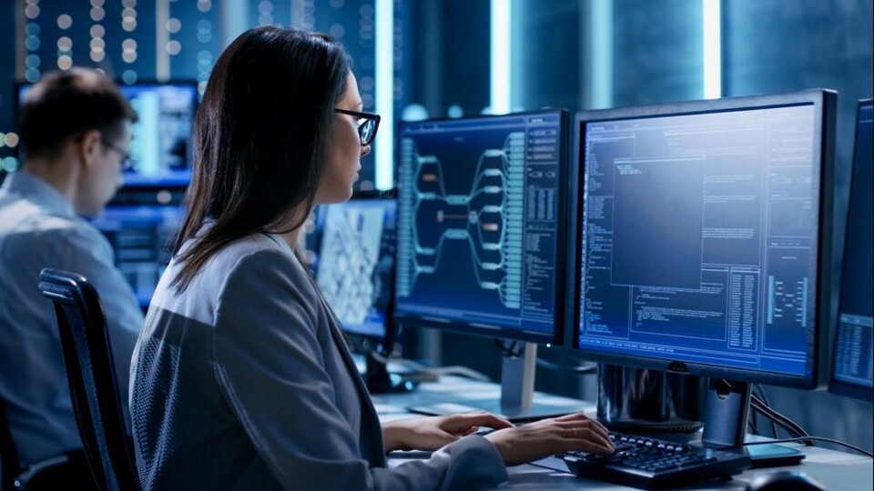 Vrouw werkt aan een computer met meer schermen