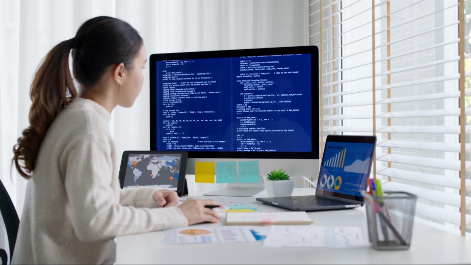 Een vrouwelijke data scientist die achter haar computer aan het werk is.