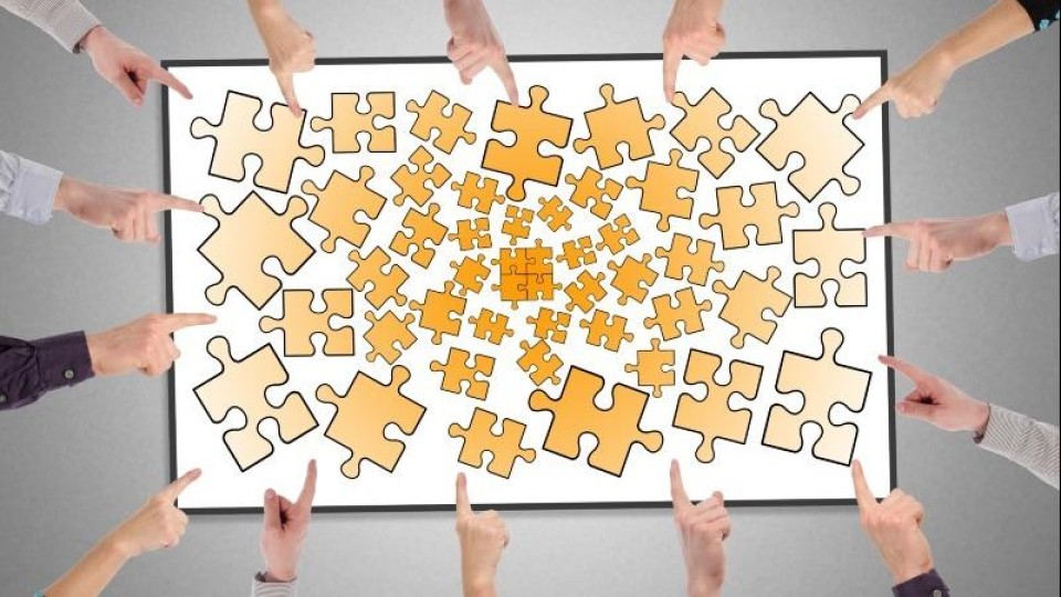Veel vingers wijzen naar een bord met ongelijke puzzelstukjes