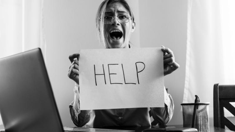 Vrouw houdt vel papier met het woord 'Help' omhoog