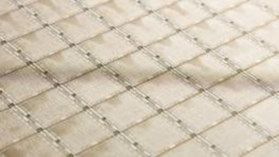Close-up van een wafer met meerdere kleine rechthoekige IBM Power10 chips in een gridpatroon.
