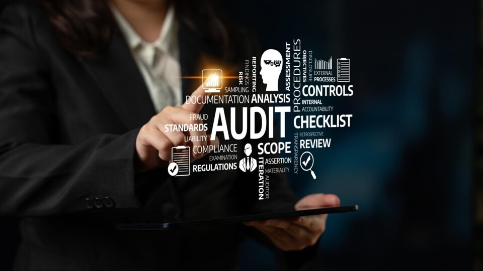 Man wijst met vinger naar een doorzichtig scherm met een woordcloud waarin inder meer Audit, controls, checklist, compliance