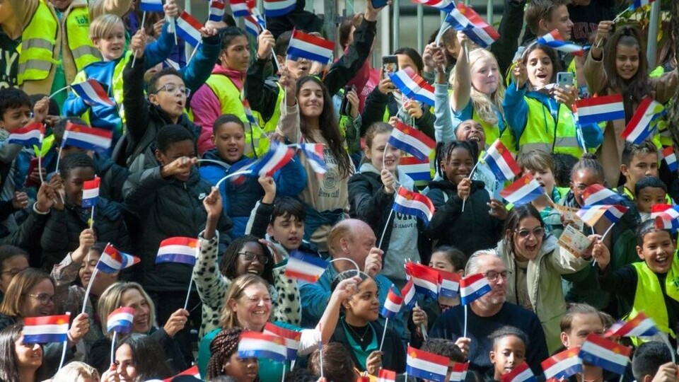 Mensen wapperen met Nederlandse vlaggetjes op Prinsjesdag