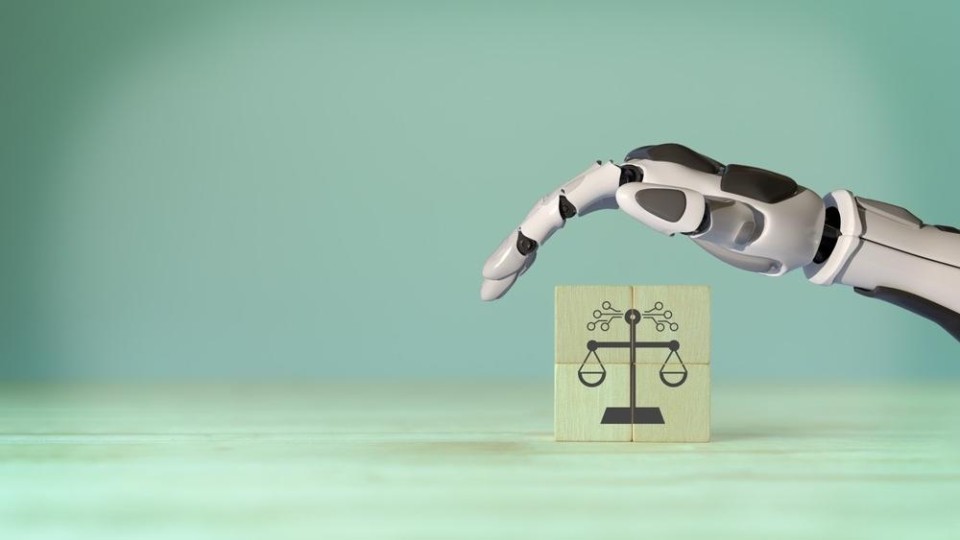 robothand en houten blokjes met daarop afbeelding van weegschaal in balans