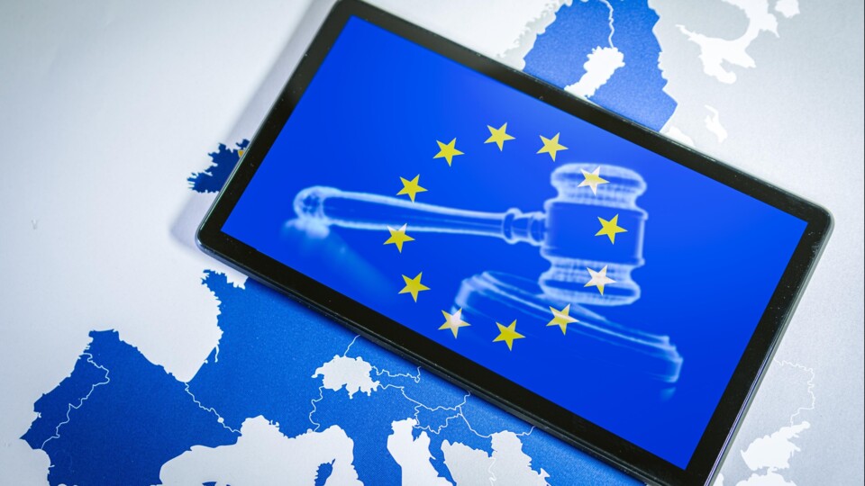 Tablet met afbeelding Europese vlag en voorzittershamer op een kaart van Europa