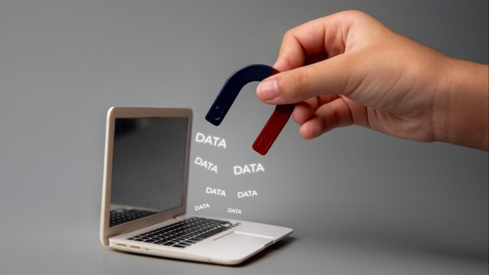Een hand die met magneet data uit een laptop trekt